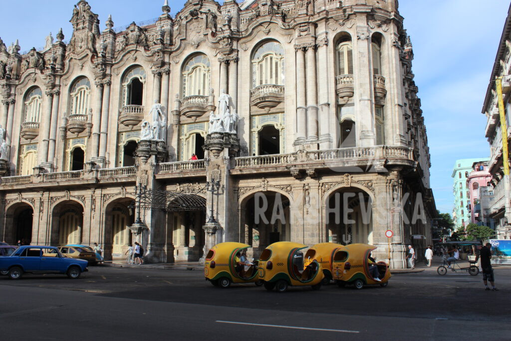 Yellow coco taxis in front of the ornate theatre